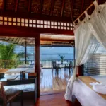 Relaxing ocean view from a tropical resort room with a private balcony.