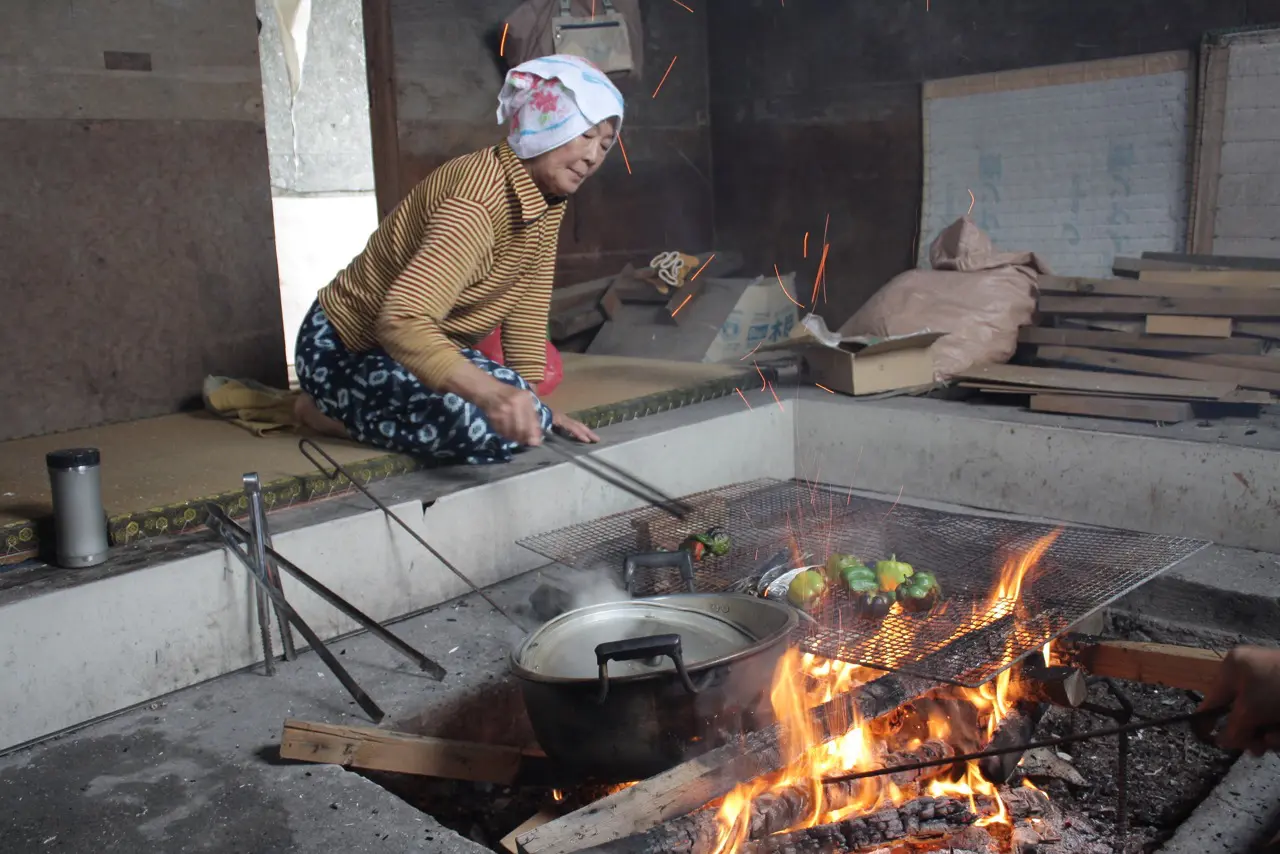 This is the real Ama goya, not the one seen by tourists. This Ama is cooking some peppers, sweet potatoes, and little fish as the other Ama prepare the catch of the day in the tourist restaurant.