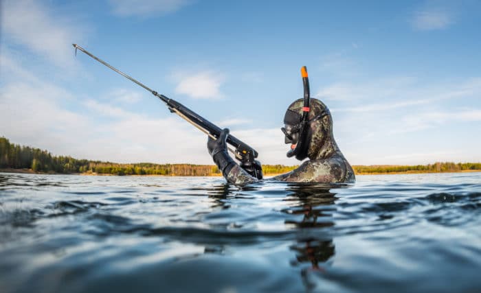 Man with speargun going to hunt in the fresh water lake