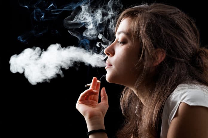 Woman Smoking a Cigarette on Black Background