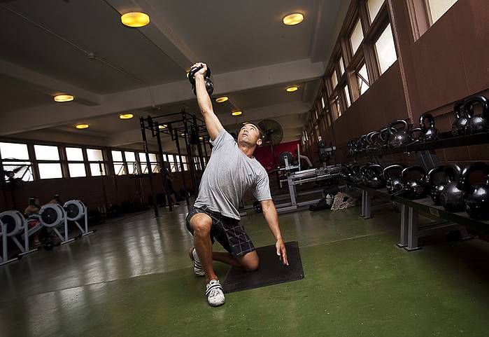 Man training a Turkish get-up at the gym