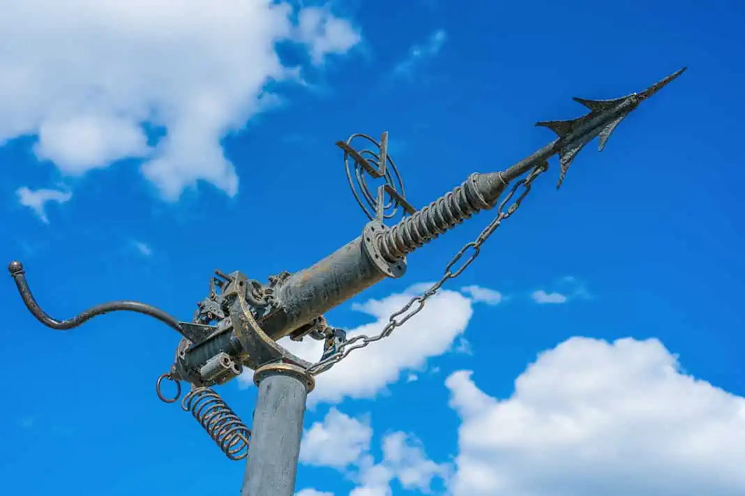 Harpoon whaling weapon on a background of blue sky with clouds. Vintage (Adobe Stock)