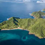 Tropical island with lush green hills and clear blue waters