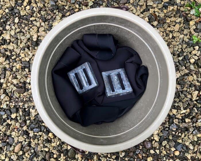 Put your neoprene wetsuit into a bucket and weigh it down.