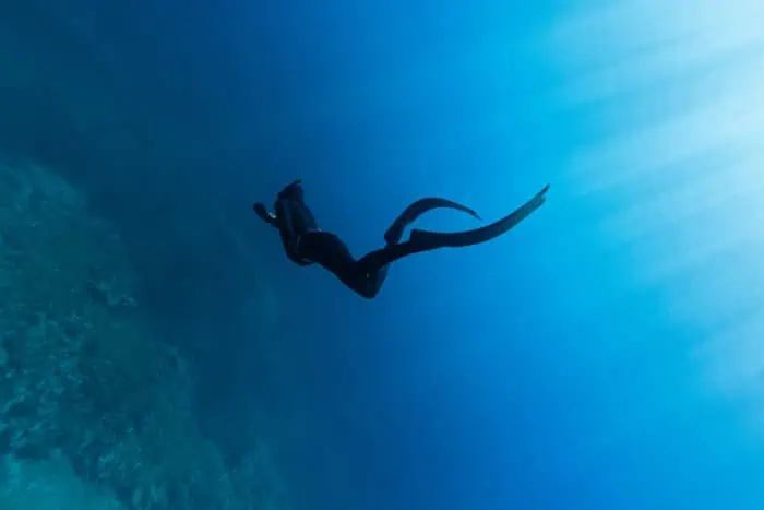 A freediver bicycle-kicking to depth