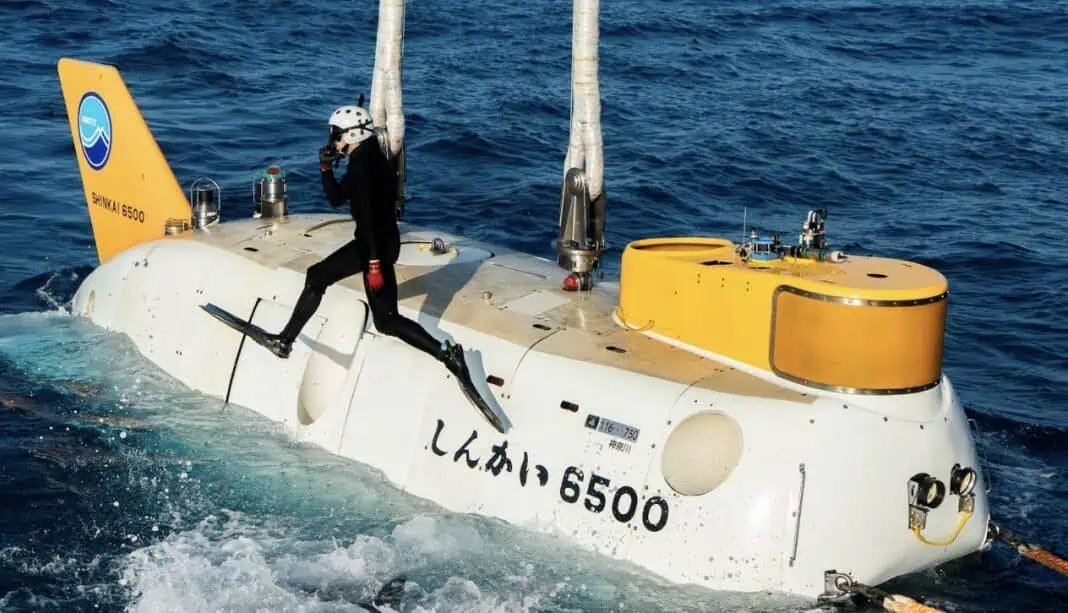 Divers jump back into the water after connecting JAMSTEC's manned submersible, Shinkai 6500 to the crane to be lifted back onto RV Yokosuka after a dive during the 2025 Ocean Census/JAMSTEC Japan Expedition. (Image Credit: The Nippon Foundation-Nekton Ocean Census/©JAMSTEC)